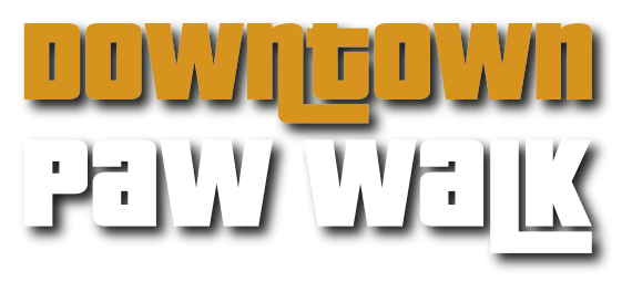 Stylized logo for 'Downtown Paw Walk.' The word 'Downtown' is in bold gold letters, and 'Paw Walk' is in bold white letters with a shadow effect. The background is transparent with a gray checkerboard pattern, commonly used to indicate image transparency.