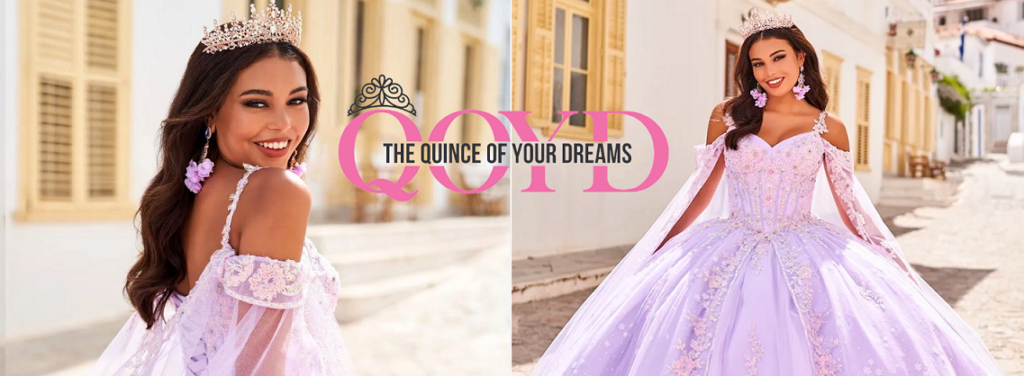 Promotional image for "The Quince of Your Dreams" (QOYD) featuring a young woman in a stunning light purple quinceañera gown embellished with delicate floral embroidery and flowing sheer sleeves. She wears a sparkling tiara and matching flower earrings, smiling brightly in both close-up and full-length shots. The background shows a picturesque cobblestone street lined with white buildings and yellow shutters. The brand name is prominently displayed in the center in pink and black lettering.