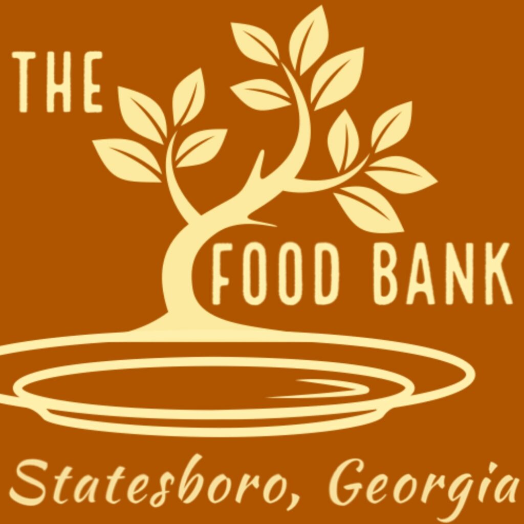Logo for The Food Bank of Statesboro, Georgia. The design features a stylized golden tree with multiple leaves, rooted in a circular plate symbol, set against a warm brown background. The words “THE FOOD BANK” are integrated into the tree and plate graphic, and “Statesboro, Georgia” is written in cursive at the bottom.