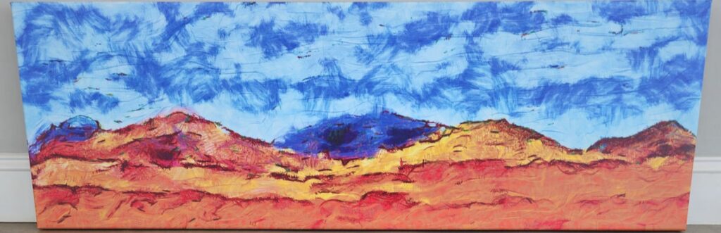 An abstract landscape painting featuring vivid colors and textured brushstrokes. The sky is a mix of vibrant blues with cloud-like streaks, while the foreground showcases rolling hills in warm tones of red, orange, and yellow, evoking a desert-like environment.