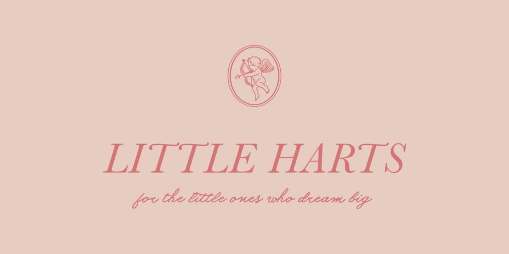 A soft pink logo for Little Harts Boutique, Statesboro's newest gem. The design features an elegant serif font for the boutique's name, 'LITTLE HARTS,' with the tagline 'for the little ones who dream big' written in a delicate cursive script below. Above the text, a small circular emblem contains a minimalist illustration of a cherub holding a bow and arrow, adding a whimsical and charming touch to the branding.