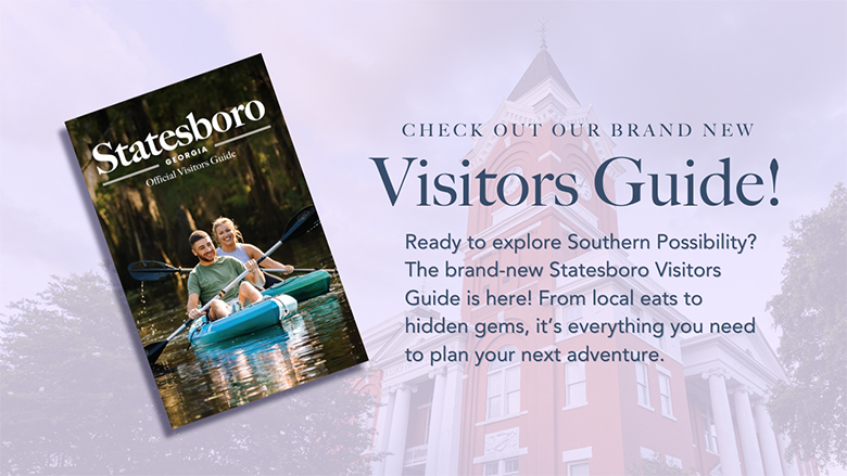 A promotional graphic for the brand-new Statesboro Visitors Guide. On the left, an image of the guide's cover features a smiling couple kayaking on a scenic waterway with lush greenery around them. The title on the cover reads 'Statesboro, Georgia - Official Visitors Guide.' On the right side, bold text announces 'CHECK OUT OUR BRAND NEW Visitors Guide!' followed by a description: 'Ready to explore Southern Possibility? The brand-new Statesboro Visitors Guide is here! From local eats to hidden gems, it's everything you need to plan your next adventure.' A button below reads 'READ THE DIGITAL EDITION.' The background features a faded image of a historic courthouse with white columns and a clock tower, enhancing the southern charm and inviting feel of the promotion.