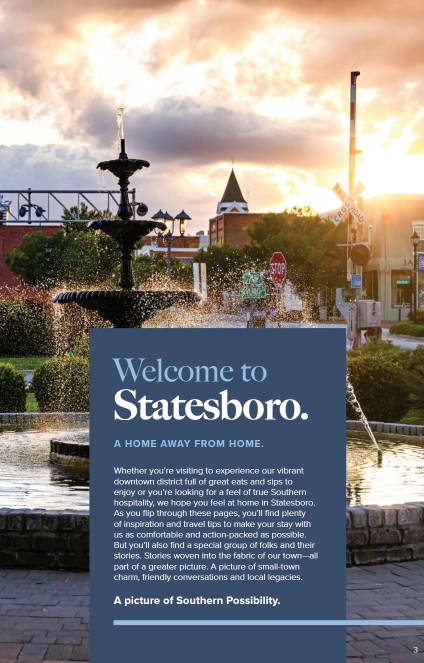 A welcome page from the Statesboro Visitors Guide featuring a picturesque fountain in the downtown area during a golden sunset. In the background, historic buildings, railroad crossing signs, and lamp posts highlight the town’s charm. A blue text box in the foreground reads: “Welcome to Statesboro. A Home Away From Home.” The paragraph below invites visitors to explore the town’s vibrant downtown district, local eats, and Southern hospitality. It emphasizes small-town charm, friendly conversations, and local stories as part of “A picture of Southern Possibility.”