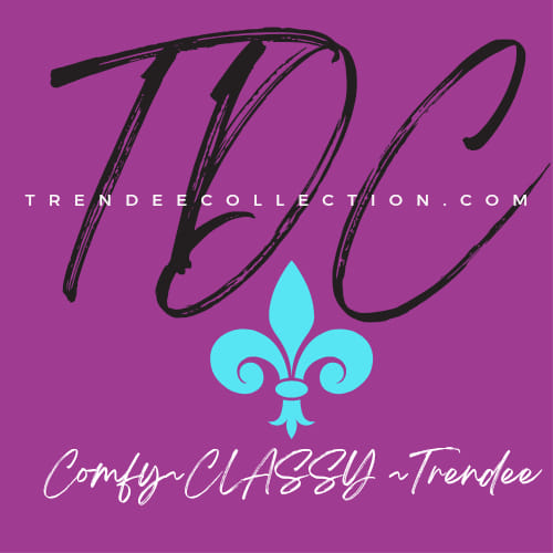 A purple square logo for Trendee Collection featuring the large, elegant initials “TDC” in black script across the center. The website “TRENDEECOLLECTION.COM” is written in white uppercase letters across the middle. Below is a turquoise fleur-de-lis icon and the slogan “Comfy ~ CLASSY ~ Trendee” in a white and turquoise script font.